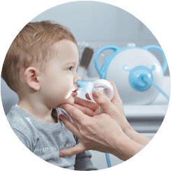 An ENT doctor clearing a boy's nose with the help of a safe baby nasal aspirator Nosiboo Pro
