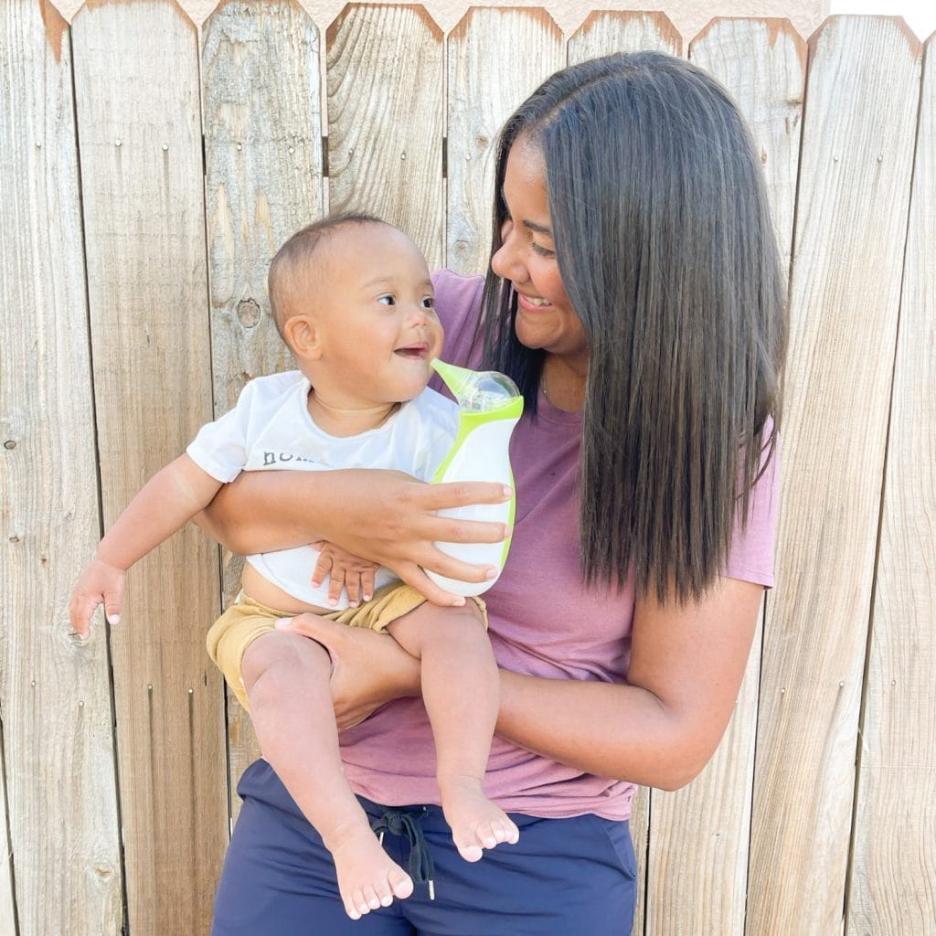 A cute, little boy held by his mother who is going to clear his nose with the help of the Nosiboo Go Electric Nasal Aspirator
