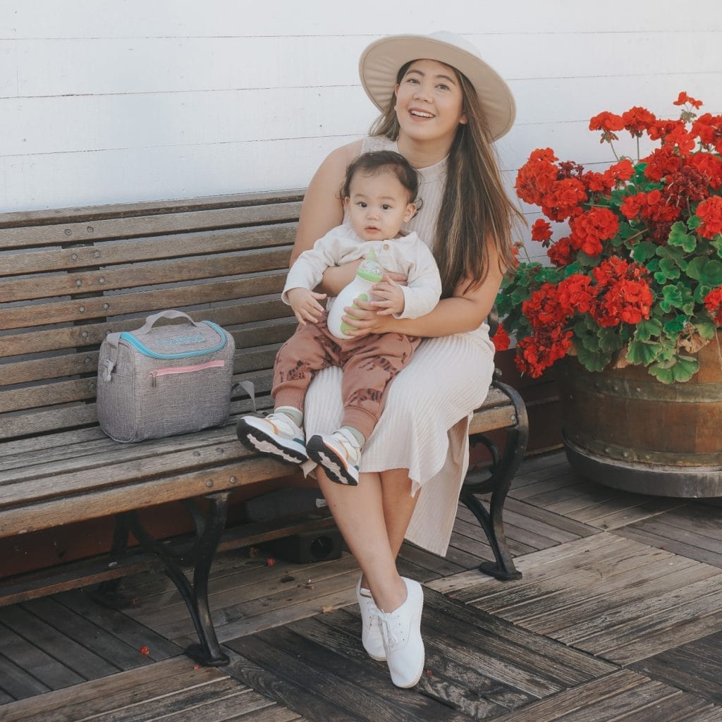 A cute, little boy held by his mother who is going to clear his nose with the help of the Nosiboo Go Electric Nasal Aspirator