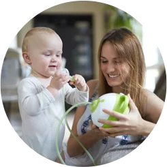 A little baby boy and his mother with the innovative Nosiboo Pro Electric Nasal Aspirator