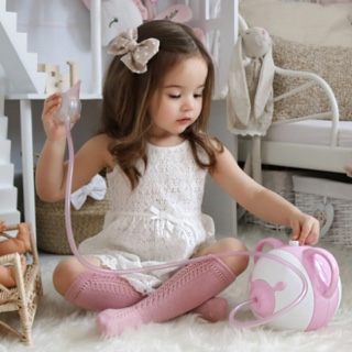 A stylish little girl in her room with the pink Nosiboo Pro Electric Nasal Aspirator