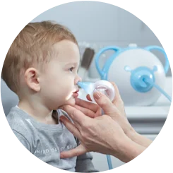 An ENT doctor clearing a boy's nose with the help of a safe baby nasal aspirator Nosiboo Pro