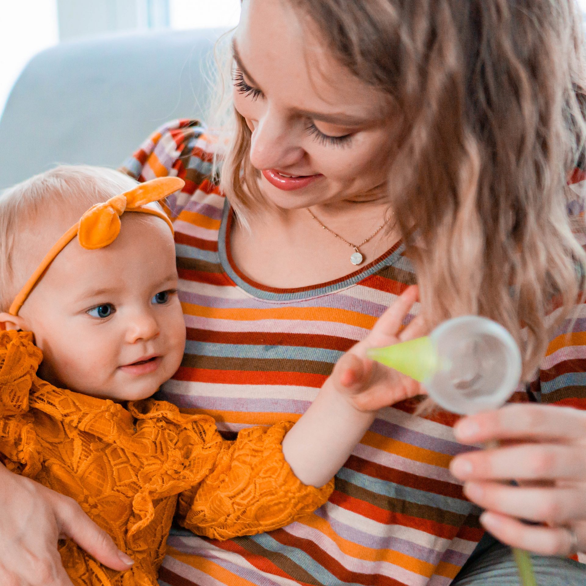 Mom with her daughter, holding a Nosiboo Pro electric nasal aspirator