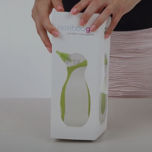 A woman holding the box of the Nosiboo Go Portable Nasal Aspirator.